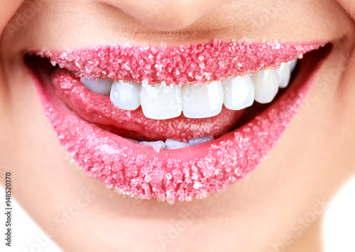 Closeup of woman's lips covered with sugar