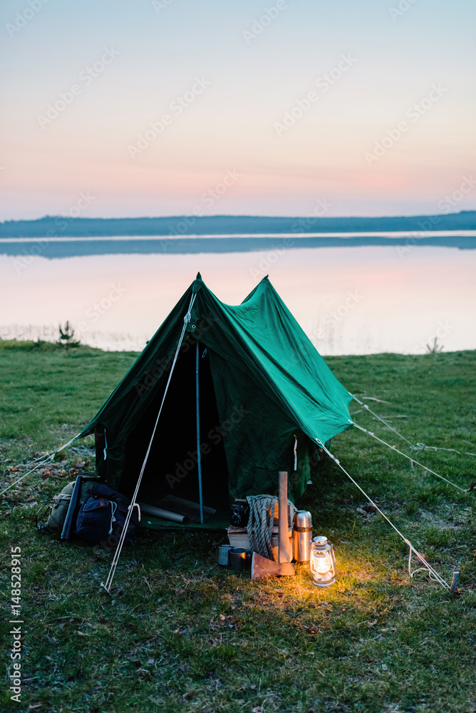 Tent on the shore of a lake, a lantern