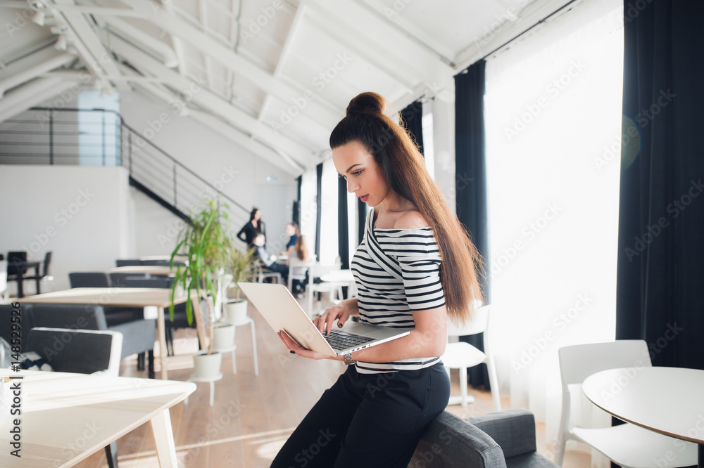 Image of woman using laptop while sitting in a cafe. Adult businesswoman sitting in a lounge and working on a personal computer. Image of woman using laptop while sitting in a cafe. Adult businesswoman sitting in a lounge and working on a personal computer.