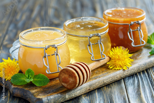 Different varieties of honey in glass jars.