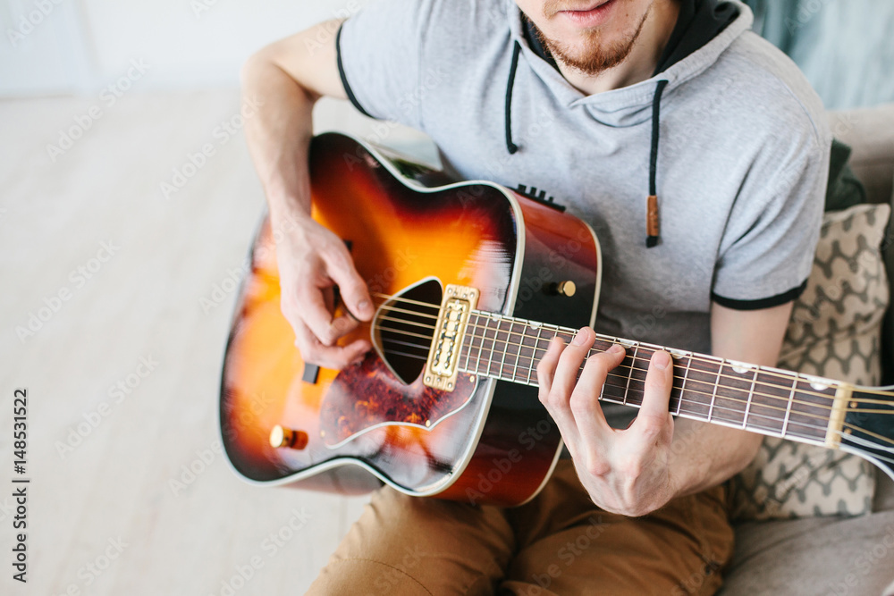 Obraz premium Learning to play the guitar. Music education and extra-curricular lessons.