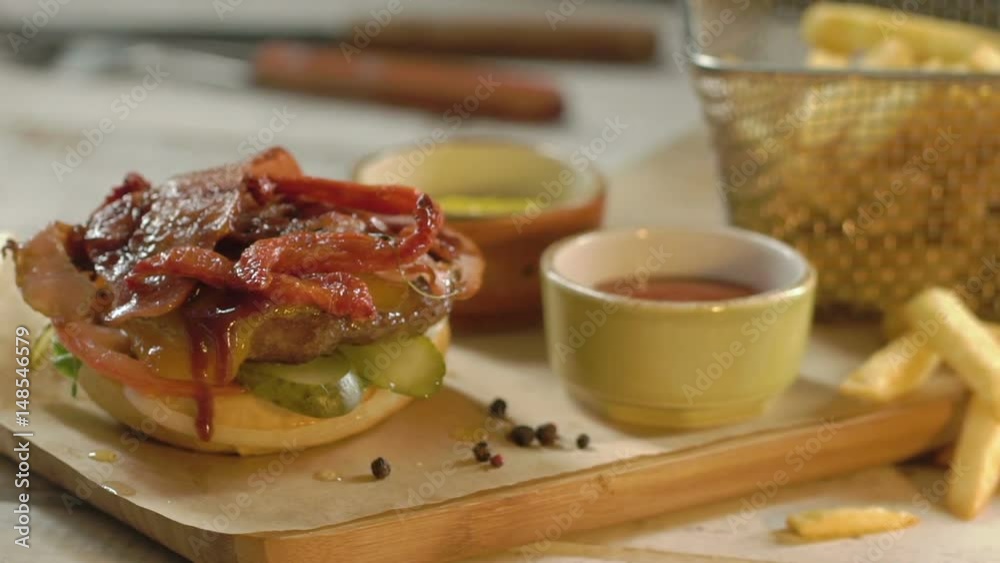 Popular fastfood: soft hamburger with fresh meat. The cook covers a burger with a sesame roll. Slow motion. Popular fastfood: soft hamburger with fresh meat. The cook covers a burger with a sesame roll. Slow motion.