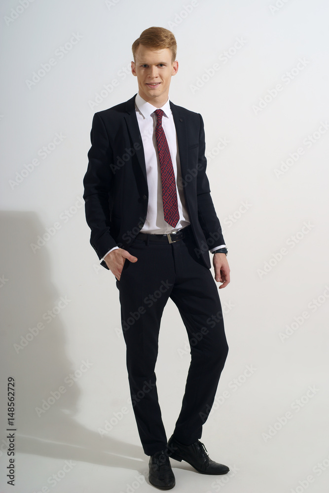 Young handsome man with red hair in black classical formal suit, white jacket and red tie Young handsome man with red hair in black classical formal suit, white jacket and red tie