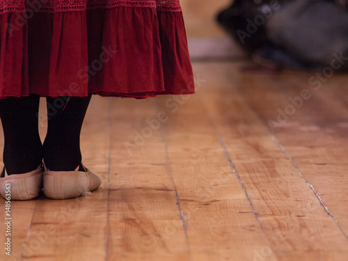 A dancer standing in a school dance room attending a lesson