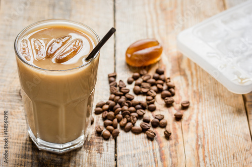 Ice coffee with milk and beans for lunch on wooden background