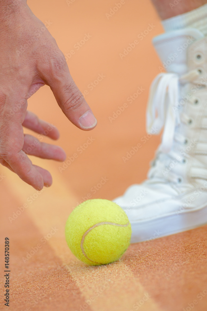 player picking up tennis ball