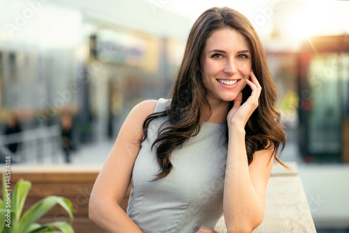 Fotografie Pretty woman enjoying sunlight on her new rooftop building patio in urban city l