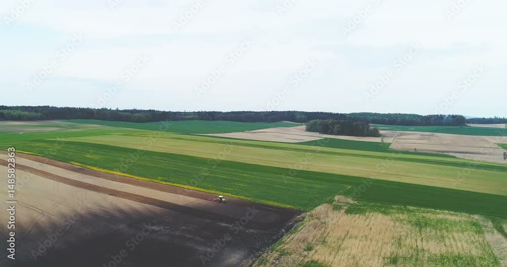 Aerial shoot of tractor working on beautiful farmland. Aerial shoot of tractor working on beautiful farmland.