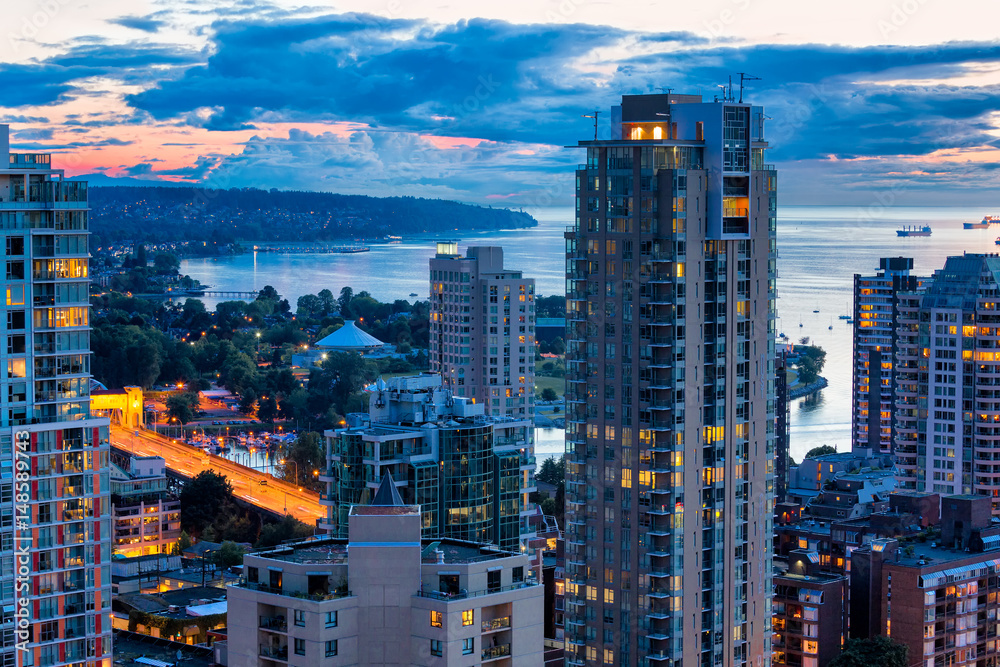 Naklejka premium Widok z lotu ptaka Vancouver Kanada na kolorowe zachód słońca. W tle widać oświetlone wieżowce i zatokę