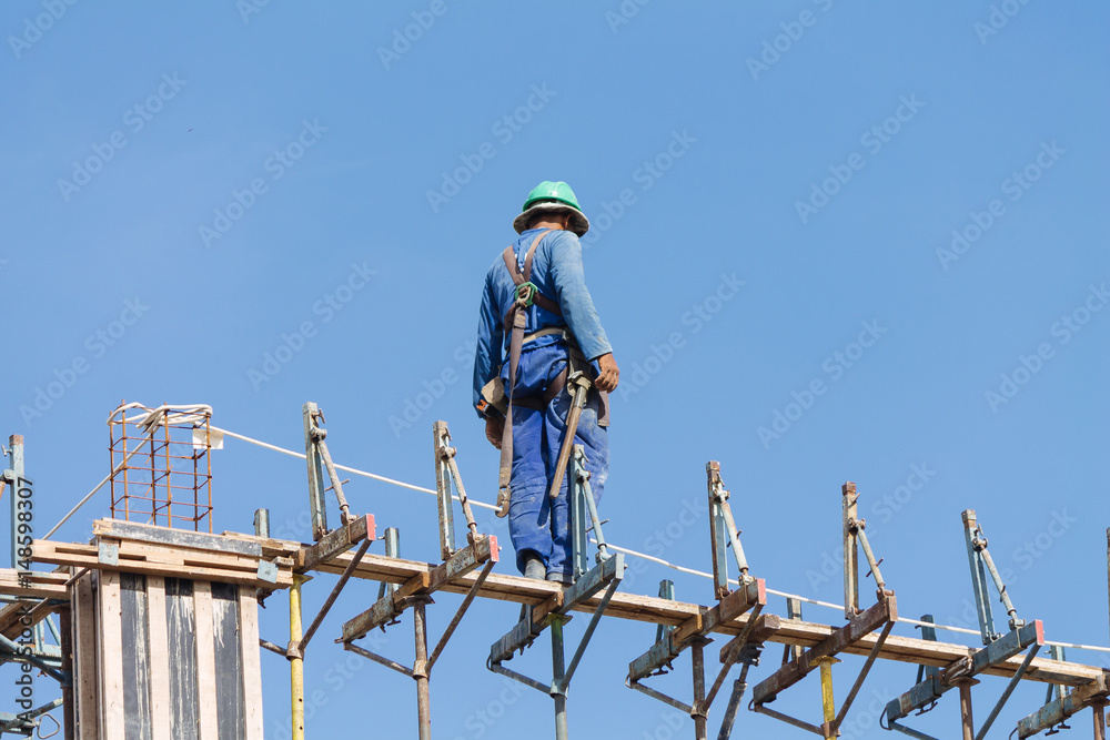 Construction worker working on top of construction site on a sunny day Construction worker working on top of construction site on a sunny day