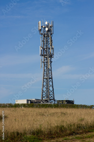 A typical radio and mobile phone network telecommunications tower situate in farmland near Groomsport in County Down, Northern Ireland makes an impressive site against a clear blue sky. photo