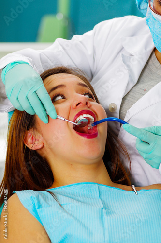 Beautiful woman patient having dental treatment at dentist s office. Woman visiting her dentist