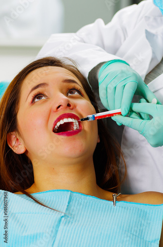 Beautiful woman patient having dental treatment at dentist's office, receiving an anesthesia injection