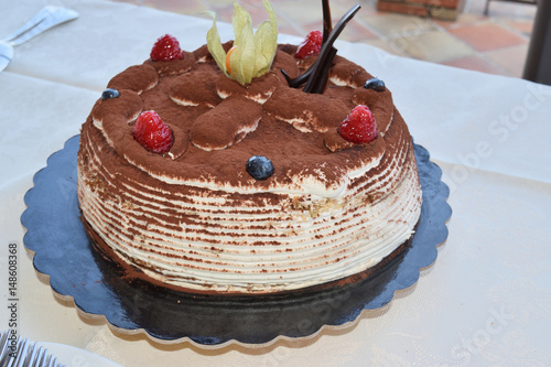 Tiramisu adorned with chocolate and fruit photo