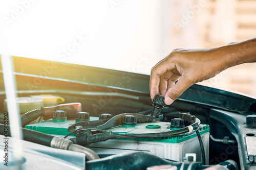Cropped image of automobile mechanic repairing car in store, day time
