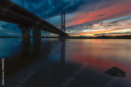 Cityscape: sunset over the river against the bridge.