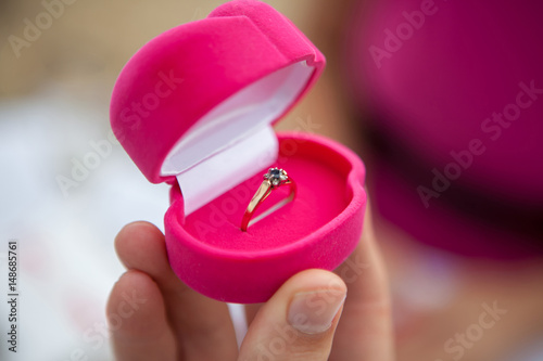 Hand with gift box and wedding ring