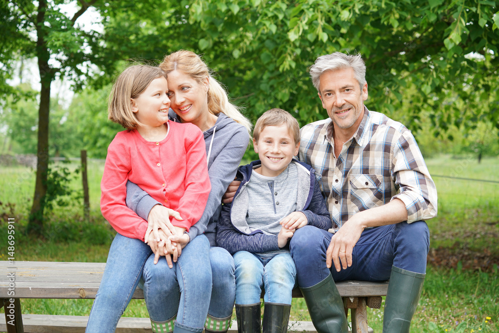 Portrait of happy family sitting on picnic table