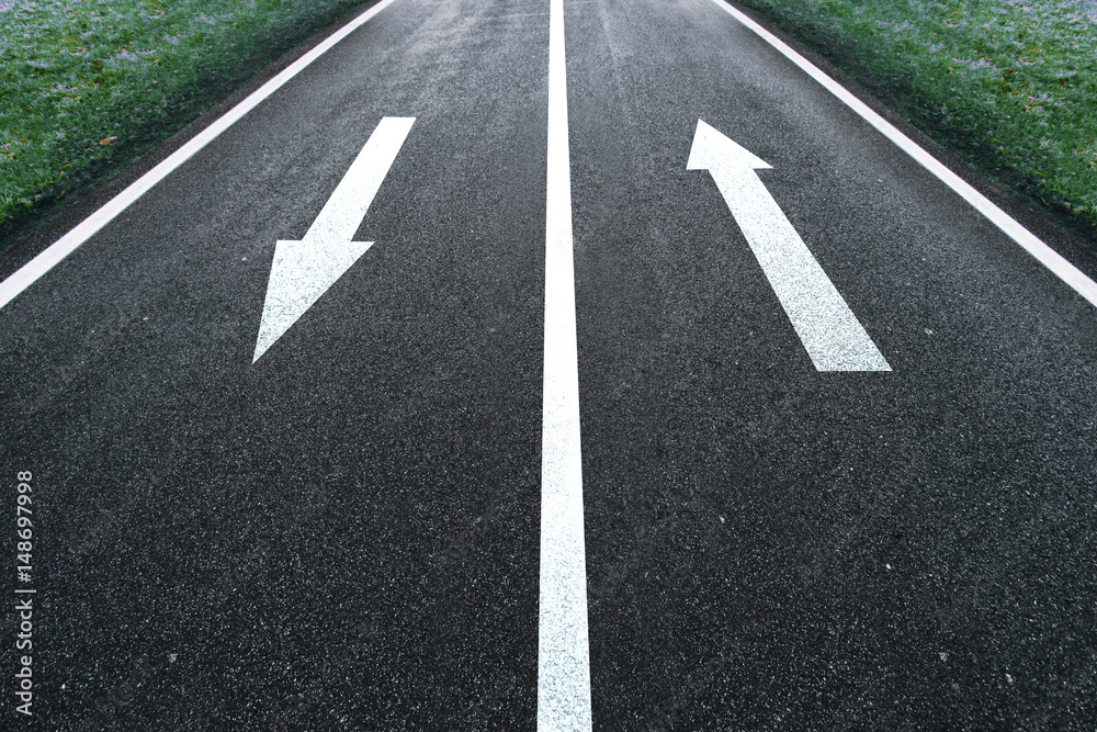 One way road arrow direction sign on the asphalt ground.