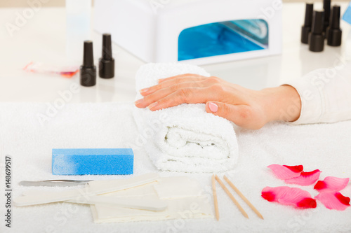Woman hand on towel  next to manicure set