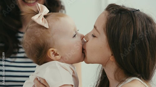 older sister kissing her baby sister