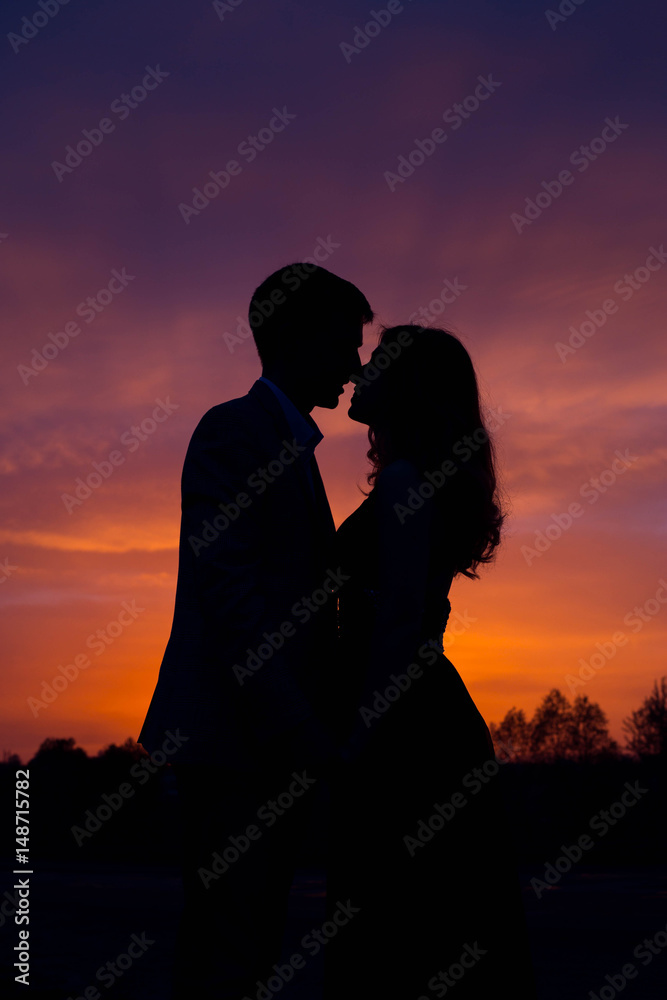 Silhouettes of couples in love at sunset.Beautiful Romantic Background. 