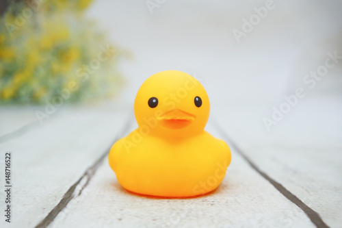 yellow duck toys over wooden table backgrounds