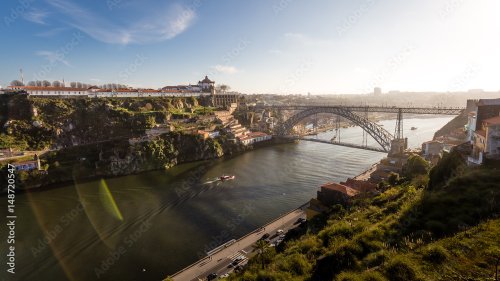Panorama of Porto (Dom Luis I Bridge and the Mosteiro da Serra do Pilar Monastery) with lens flare against blue sky