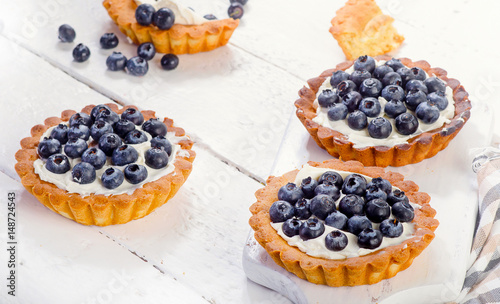 Sweet Blueberry tarts on white wooden board