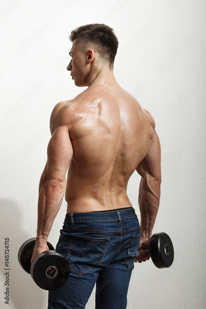 Sportsman performing exercises with dumbbells Sportsman performing exercises with dumbbells