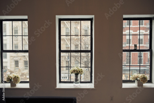 Three bouquets stand on three windowsills in the room