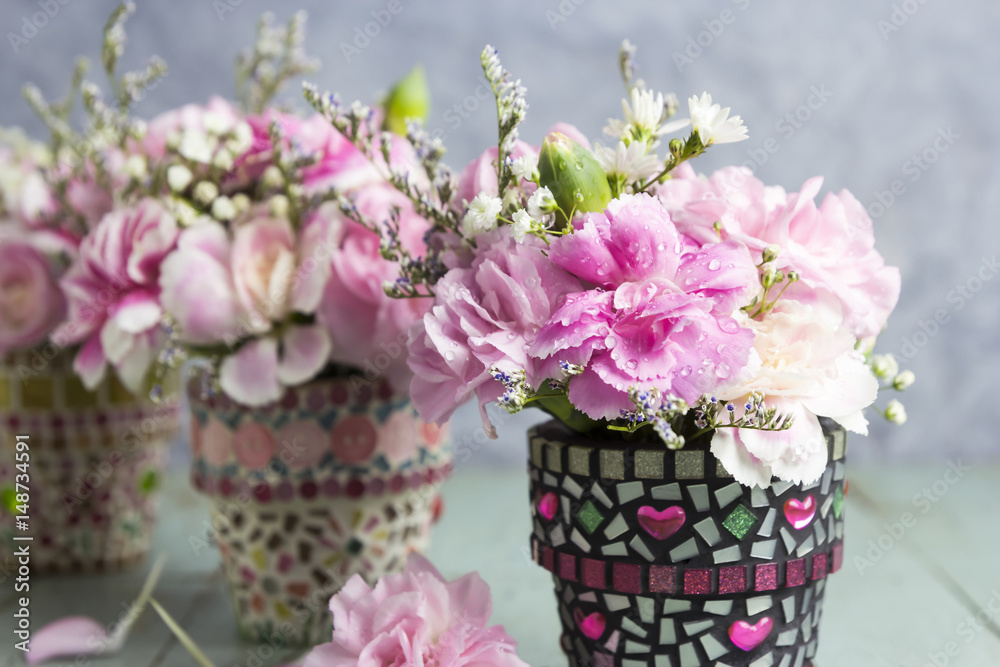 Carnation in mosaic flower pot on old wood Carnation in mosaic flower pot on old wood