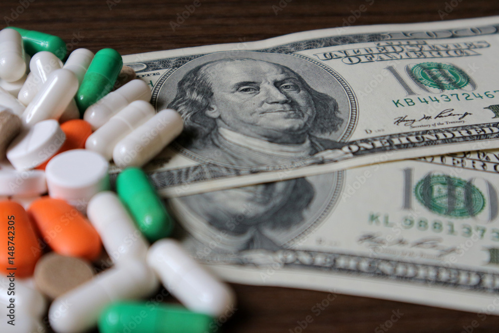Dollars and pills, a budget for treatment, expensive medications, drug prices in a pharmacy. Dollars and pills, a budget for treatment, expensive medications, drug prices in a pharmacy.