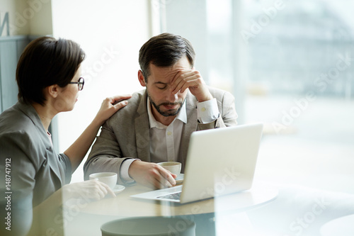 Businesswoman comforting frustrated or tired co-worker
