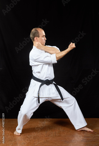 On a black background, the master trains karate blocks © andreyfire