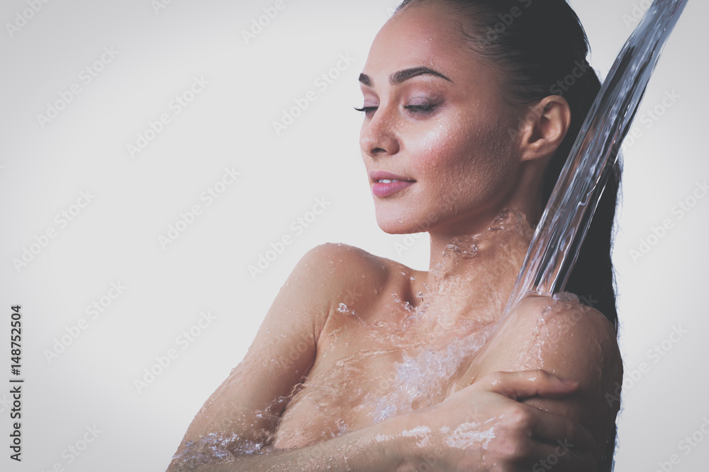 Young beautyful woman under shower in bathroom Young beautyful woman under shower in bathroom