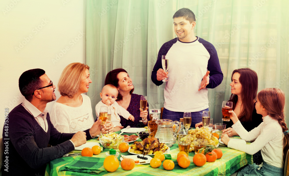 Cheerful multigenerational family sitting at holiday table