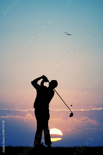 men play golf at sunset
