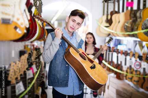 Teenage choosing best acoustic guitar