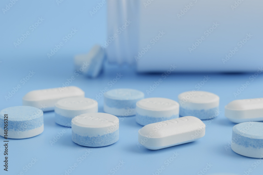 white pills on the soft blue background with soft focus style. paracetamol 500 mg. white pills on the soft blue background with soft focus style. paracetamol 500 mg.