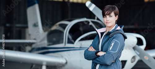 Smiling female pilot posing with her plane