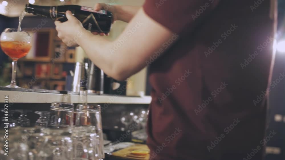 The barman at the bar prepares a cocktail