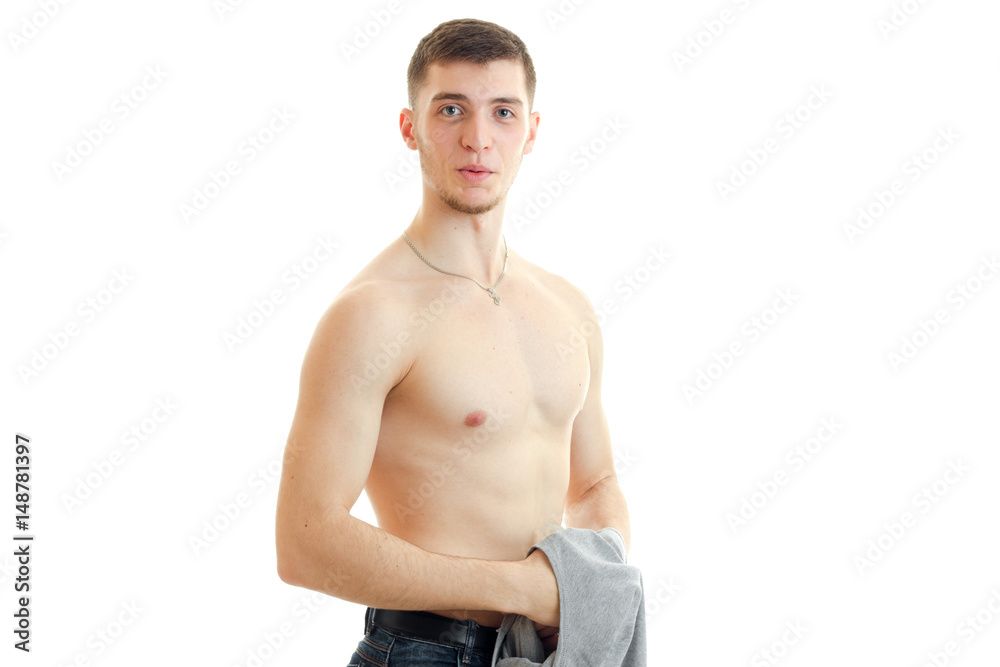 young guy with a nice body looks into the camera and holds Mike young guy with a nice body looks into the camera and holds Mike