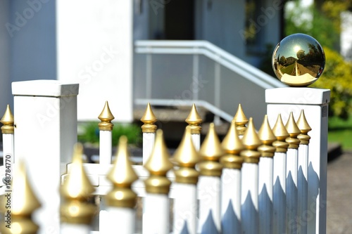 Moderner Lattenzaun mit Goldkugeln als Grundstücksabgrenzung photo