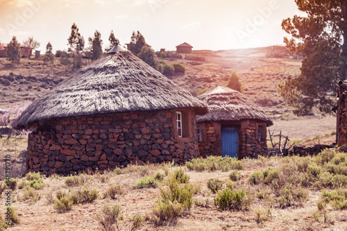 Sunset behind Lesotho huts photo