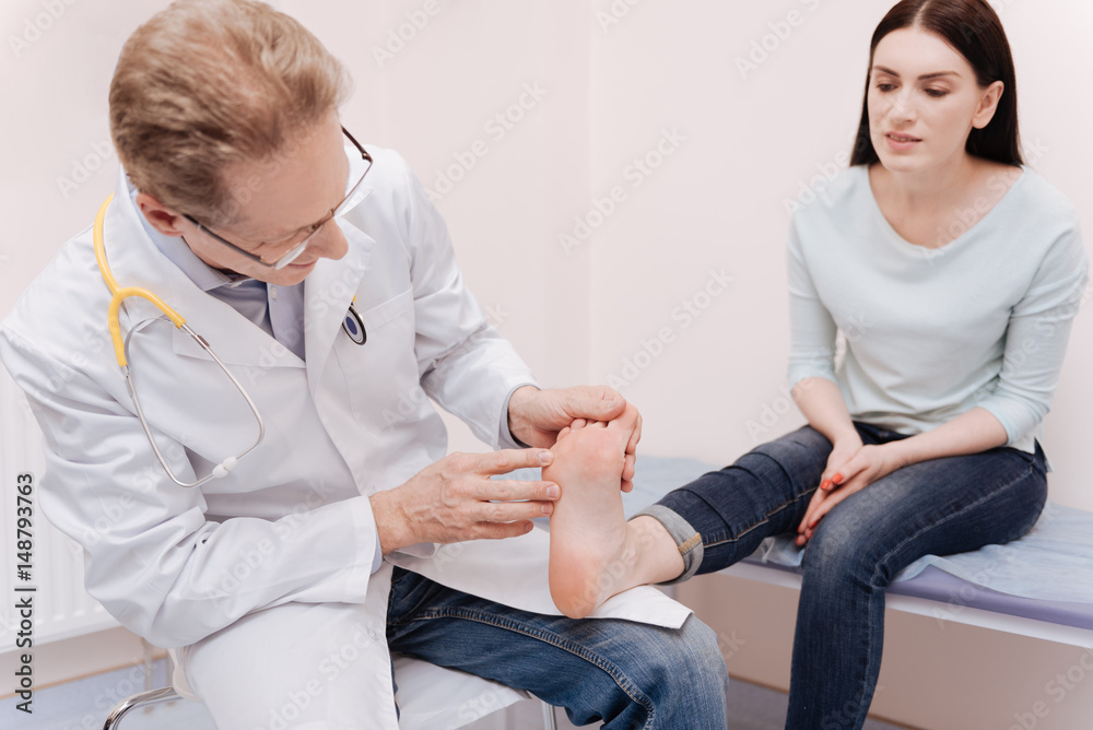Obraz premium Intent local expert examining ladies foot