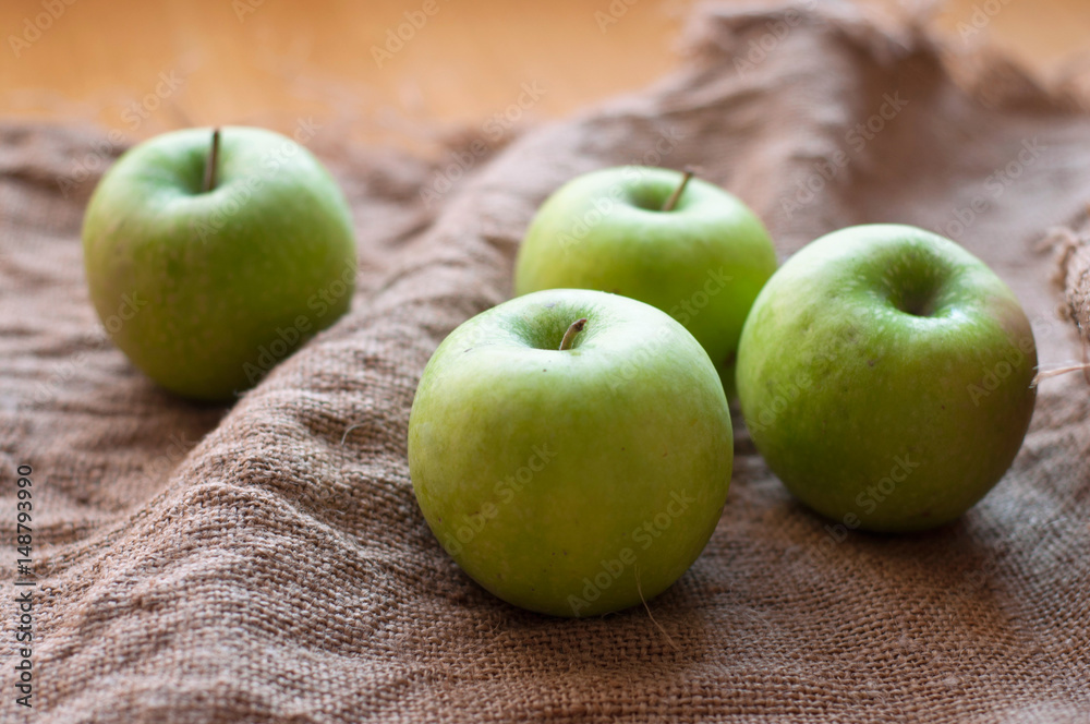Green apples on the sackcloth texture background Green apples on the sackcloth texture background