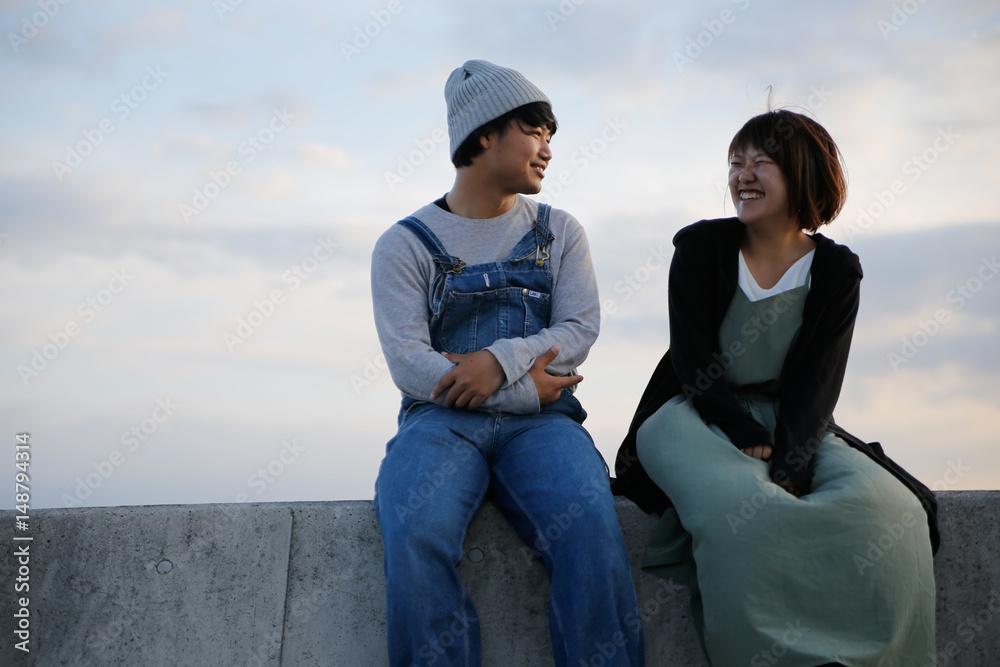 young couple sitting in a breakwater