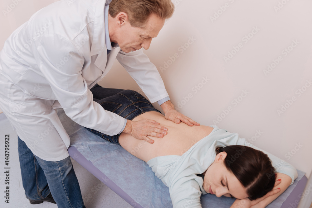 Careful excellent specialist doing treating massage Careful excellent specialist doing treating massage