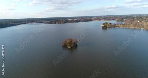 Lake bodom, Cinema 4k aerial flight around a little island on bodom lake, on a sunny spring day, in Espoo, Finland photo